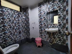 a bathroom with a sink and a toilet and a mirror at Hotel Vraj in Rājpīpla +46 photos