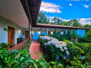 une maison avec un jardin fleuri sur une terrasse couverte dans l'établissement Hotel Rural El Retiro de San Pedro by RetiroRural, à Arenas de San Pedro