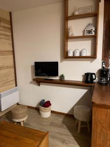 a kitchen with a flat screen tv on a wall at Appartement 4 personnes BAT B02 in Gresse-en-Vercors