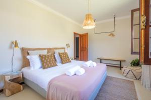 sypialnia z dużym łóżkiem z ręcznikami w obiekcie Portugal Active Cabedelo Beach Lodge - Heated Pool w mieście Viana do Castelo