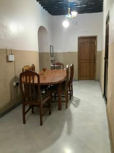 a dining room with a wooden table and chairs at Zebra House Stonetown in Ngambo