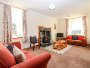 a living room with a couch and a fireplace at Wynford Holiday Cottage in Aberdeen