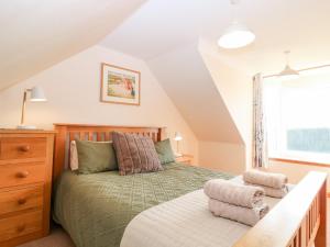 a bedroom with a green bed and a window at Wynford Holiday Cottage in Aberdeen