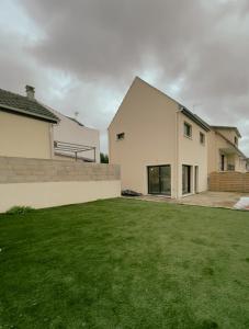 uma casa branca com um relvado à frente em Maison moderne proche CDG, Paris em Tremblay En France