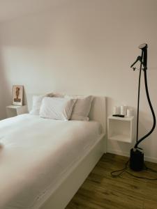 um quarto com uma cama branca e um candeeiro preto em Maison moderne proche CDG, Paris em Tremblay En France