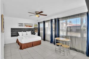 a bedroom with a bed and a table and some windows at Coastal Sunset in Hollywood +46 photos