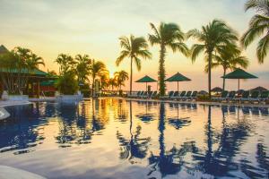 una gran piscina con palmeras y sombrillas en Grand Decameron Panama, A Trademark All Inclusive Resort, en Playa Blanca