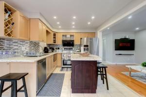 a kitchen with wooden cabinets and a large island at 4-BR Family Haven - Near Wonderland and Vaughan Mills in Vaughan