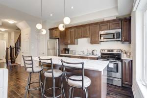 a kitchen with wooden cabinets and a kitchen island with bar stools at Hamilton 3BR Gem - Comfort Stay, City and Nature Mix in Hamilton