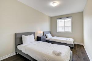 two beds in a small room with a window at Hamilton 3BR Gem - Comfort Stay, City and Nature Mix in Hamilton