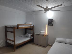 1 dormitorio con literas y ventilador de techo en La casa del mar, en San Bernardo del Viento
