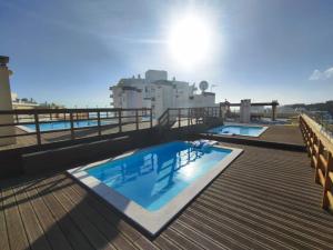 two swimming pools on the roof of a building at Armação de Pêra Ocean Terrace With Pool by Homing in Armação de Pêra