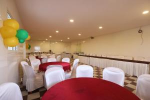 een kamer met rode en witte stoelen en tafels en ballonnen bij NO 7 Grandeur Hotel in Bangalore