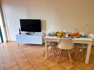 a dining room with a table and a television at Armação de Pêra Ocean Terrace With Pool by Homing in Armação de Pêra