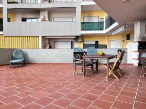 a patio with a table and chairs and a building at Armação de Pêra Ocean Terrace With Pool by Homing in Armação de Pêra