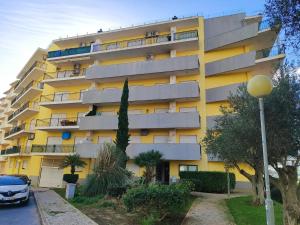 a yellow building with a car parked in front of it at Armação de Pêra Ocean Terrace With Pool by Homing in Armação de Pêra