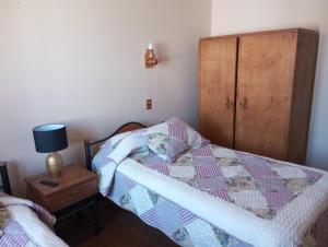 una camera con un letto con una trapunta sopra di Hostal Tierra de Pehuen a Curacautín
