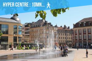 a fountain in the middle of a city with buildings at Le Haut Cloquais - SereniStay in Metz