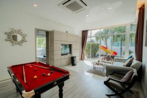 a living room with a red pool table in it at City Beach Cha-am Pool Villa in Cha Am
