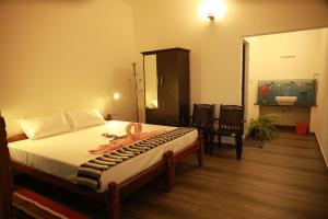 ein Schlafzimmer mit einem Bett und ein Badezimmer mit einem Waschbecken in der Unterkunft Marari Sophy Villa in Mararikulam