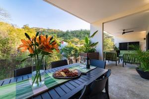 a table with a plate of food and flowers on a balcony at 3018 - Ziba Condo 208 in Santa Cruz Huatulco
