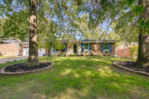 una casa con dos árboles en un patio en Sunland Hills Home with Theater Room and Fire Pit!, en Florissant