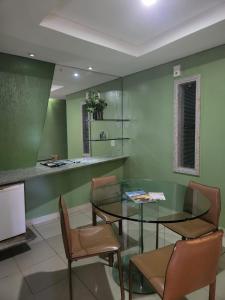 uma sala de jantar com uma mesa de vidro e cadeiras em Status Motel PE15 (Adults Only) em Olinda