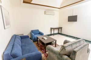 a living room with two blue couches and a table at Delmon Hotel Suites in Jeddah