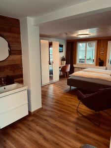 a bedroom with a bed and a sink at Boutique Hotel Bellevue B&B am Brienzersee Iseltwald Interlaken in Iseltwald