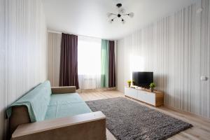 a living room with a bed and a television at 2-ком Костанай Плаза, Тобол Арена, Allur auto, заводы, Береке in Kostanay