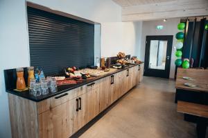 a large kitchen with a long counter with food on it at Kleiter´s BERGLERGHÜS in Blaichach