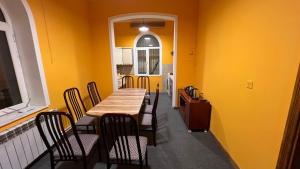 une salle à manger avec des murs jaunes, une table et des chaises dans l'établissement Mexx Hostel, à Baku