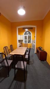 une table et des chaises dans une pièce aux murs jaunes dans l'établissement Mexx Hostel, à Baku
