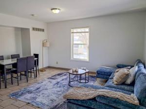 ein Wohnzimmer mit einem blauen Sofa und einem Tisch in der Unterkunft Comfort & Cozy 3/2 in Macomb, IL in Macomb