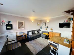 ein Wohnzimmer mit einem Sofa und einem Tisch in der Unterkunft Characterful & cosy cottage with large double room in Manningtree