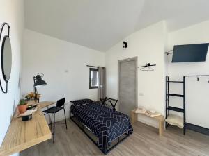 Schlafzimmer mit einem Bett, einem Tisch und einem Schreibtisch in der Unterkunft Civico36 in Ilbono