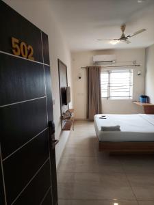 a hotel room with a bed and a window at Elevar Ayanna in Bangalore
