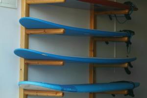 un estante con tres tablas de surf azules. en Peak House Imsouane en Imsouane