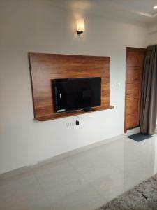 a living room with a flat screen tv on a wall at Elevar Ayanna in Bangalore