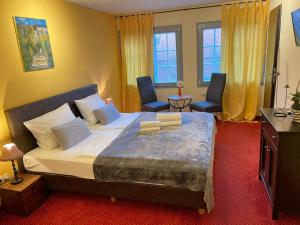 um quarto com uma cama grande e 2 cadeiras em Hotel Restaurant Iris em Bad Segeberg