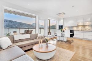 a living room with a couch and a table at Beautiful home with seaview in Tromsø