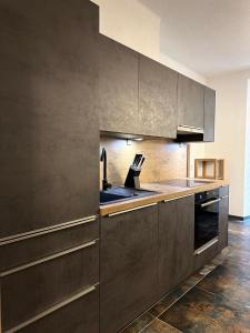 a kitchen with stainless steel cabinets and a sink at Stilvoll renovierte Wohnung in Lienz