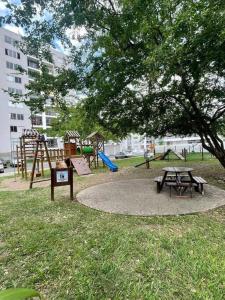 un parque con un parque infantil con una mesa de picnic y un árbol en hermoso apartamento con piscina en Yumbo