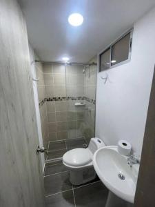 Baño pequeño con aseo y lavamanos en hermoso apartamento con piscina en Yumbo