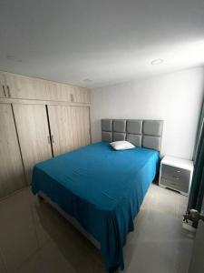 een slaapkamer met een blauw bed in een kamer bij hermoso apartamento con piscina in Yumbo