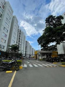 een motorfiets geparkeerd op een parkeerplaats naast hoge gebouwen bij hermoso apartamento con piscina in Yumbo