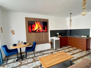 a kitchen with a table and a fire in the wall at Blue Apartment Pirin Golf & Spa in Bansko