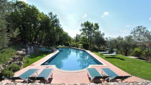 a swimming pool with lounge chairs next to a yard at Il Sole in Gaiole in Chianti