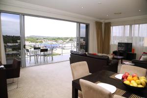 トゥーンバにあるToowoomba Central Plaza Apartment Hotel Officialのテーブルと椅子、バルコニーのあるリビングルーム