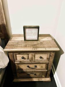 a wooden dresser with a sign on top of it at The Gateway: Entire Apartment 7 mins from airport in Cleveland